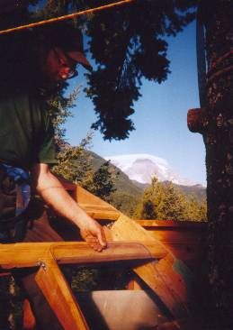 Framing in a recycled car window in one of the arched roof sections.  (Note cloud cap over Mt. Rainier in background ...  indicates rain is on the way in a day or two.)
